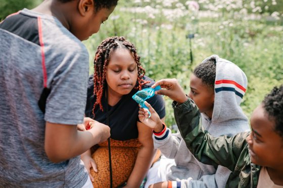 Young students smelling a packet of herbs. 